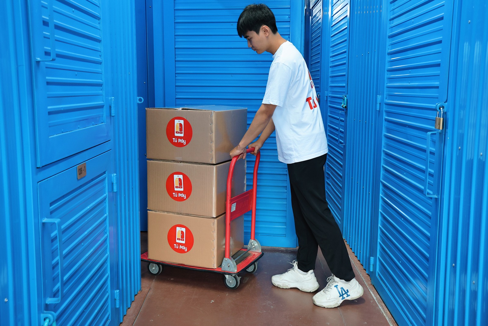 A crew member wheeling a load along the aisle between units