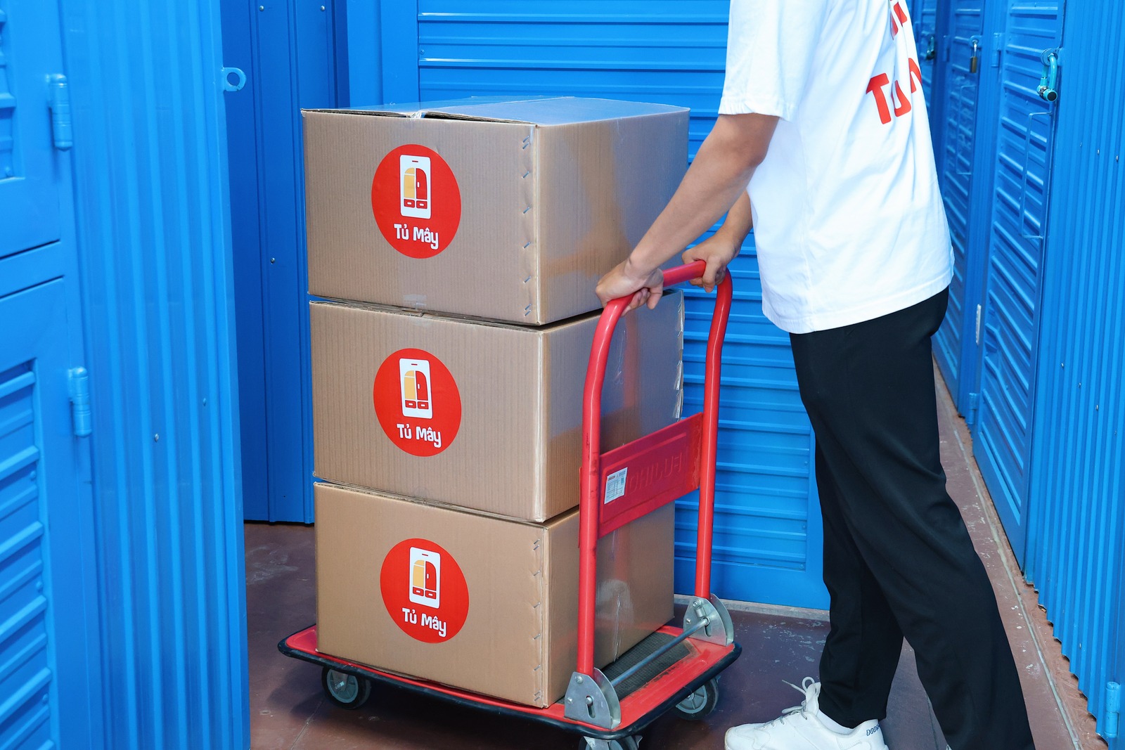 A trolley carrying three Tủ Mây boxes down the corridor