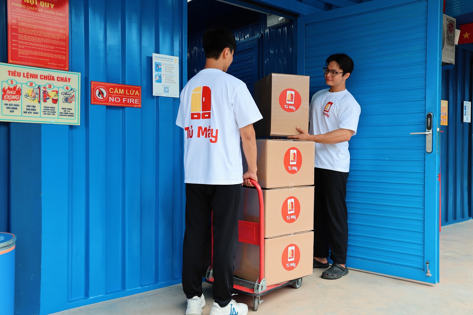 Two crew members bringing boxes in past the fire regulations board