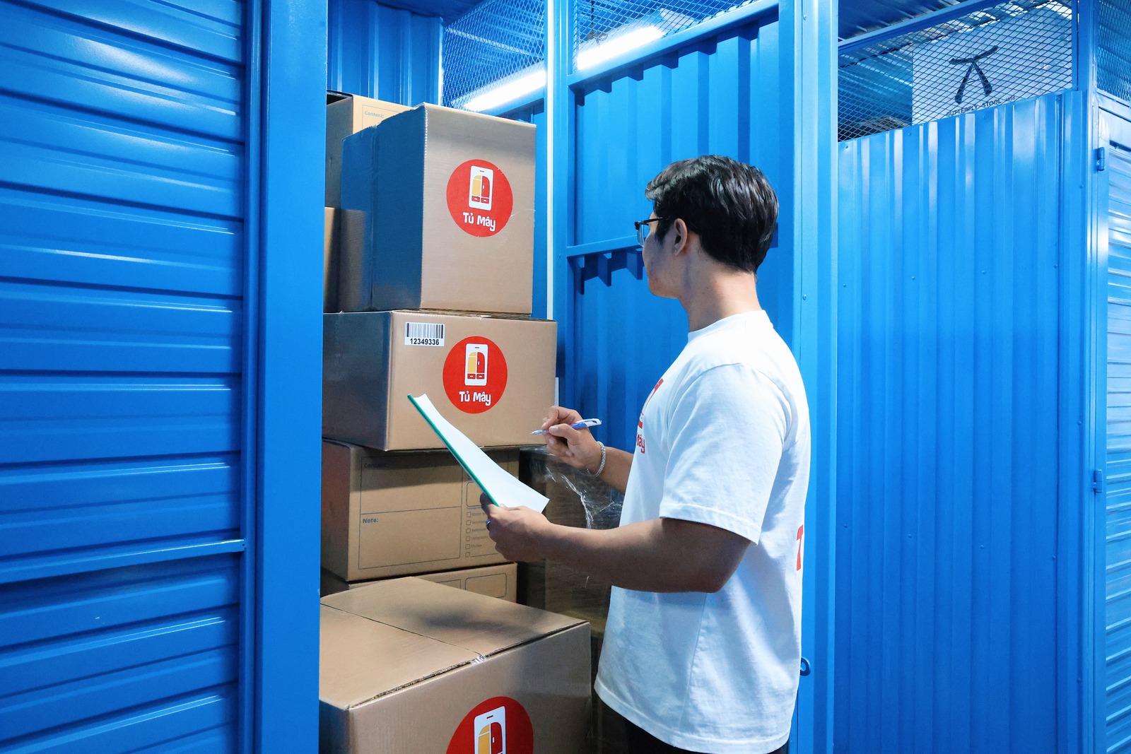 A crew member checking a printed list against the boxes in a unit