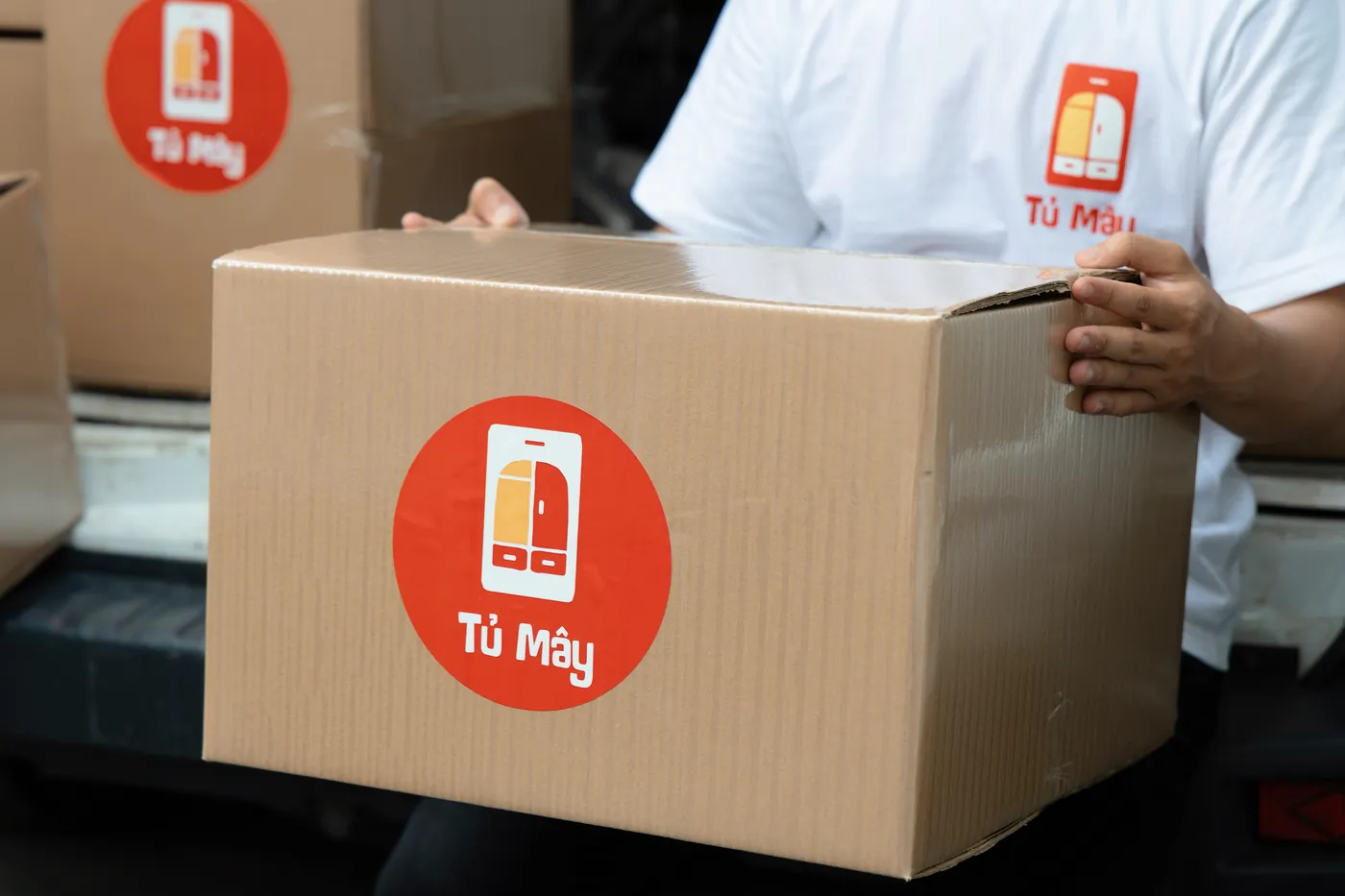 A Tủ Mây box carried close to camera, the red logo facing out