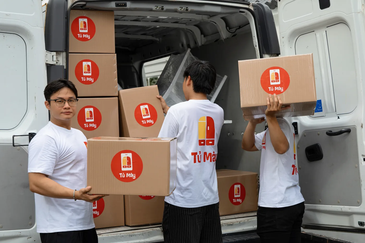 Crew members carrying boxes off the van