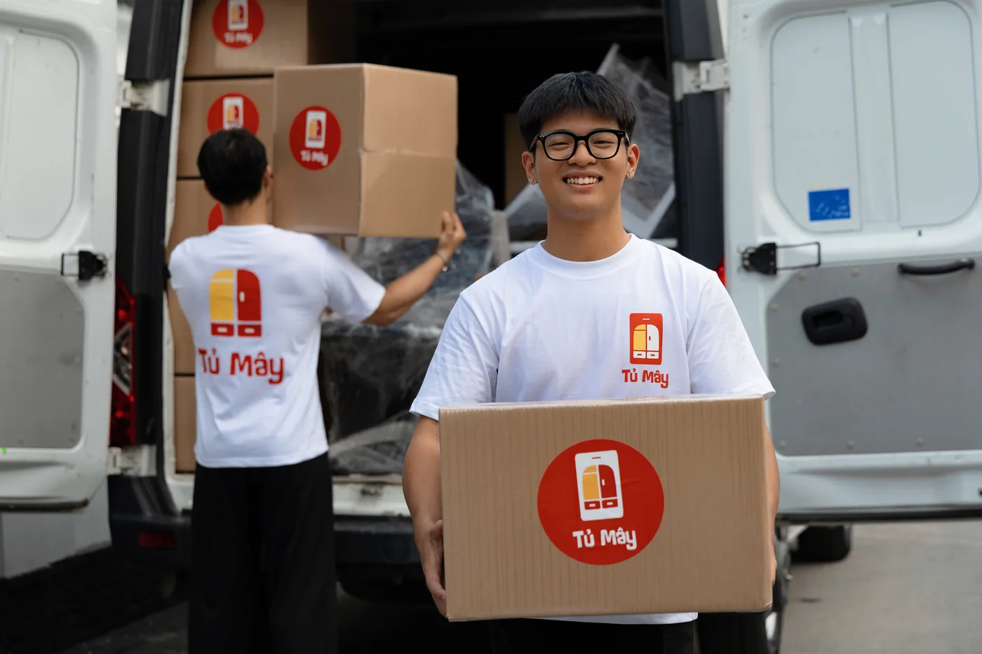 Crew member passing a box up into the van