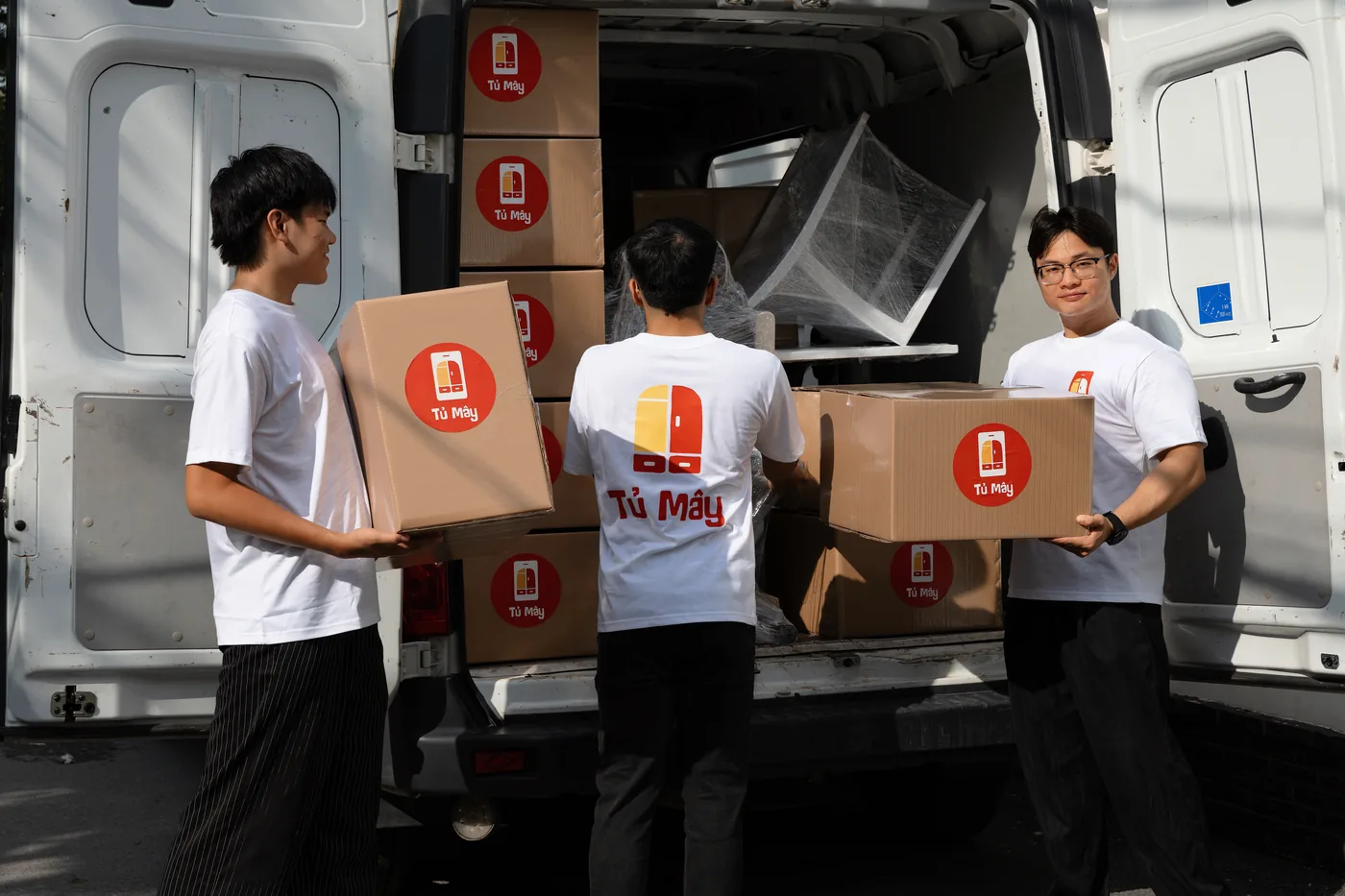 Three crew members loading boxes into the van