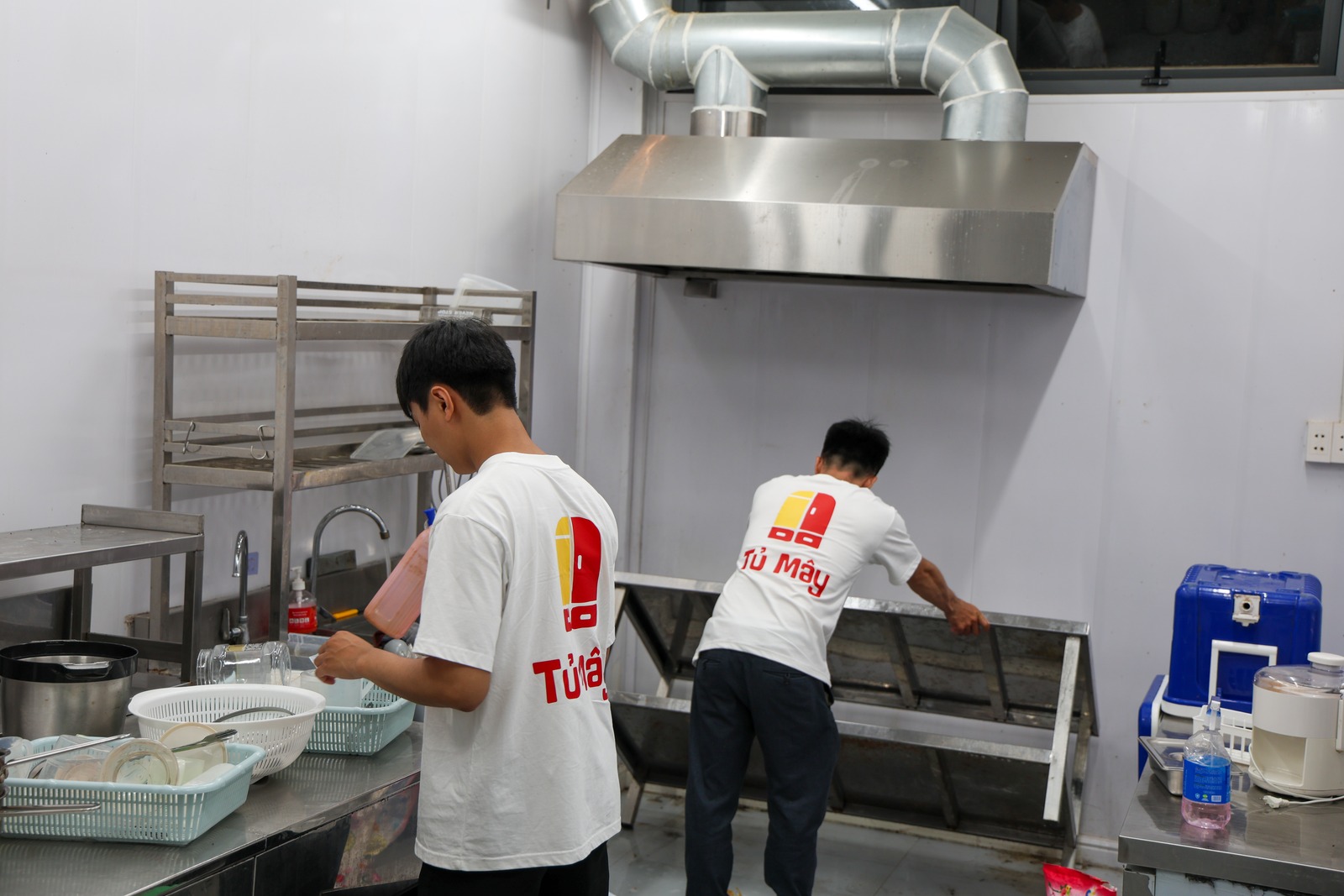 A crew member cleaning under the extraction hood