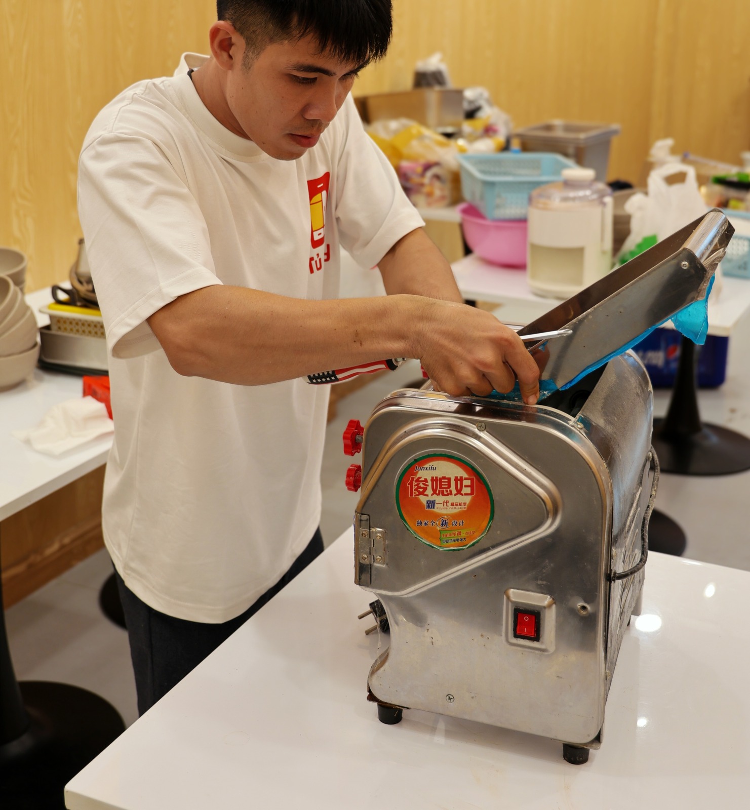 A crew member removing the blade from a dough sheeter before packing